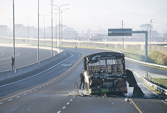 Vypálený autobus hyzdí silnici na předměstí Kapského města, které zažilo týden...