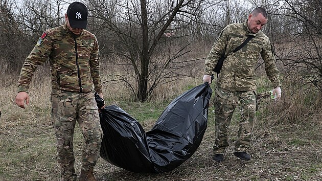 Ukrajintí vojáci odnáejí z bojit tlo ruského vojáka nedaleko Kupjanska v...