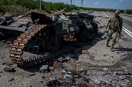 Ukrajinský voják prochází kolem znieného ukrajinského tanku nedaleko obce...