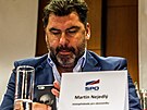 Konference strany SPO. Martin Nejedlý píe na telefonu s podobiznou Vladimíra...
