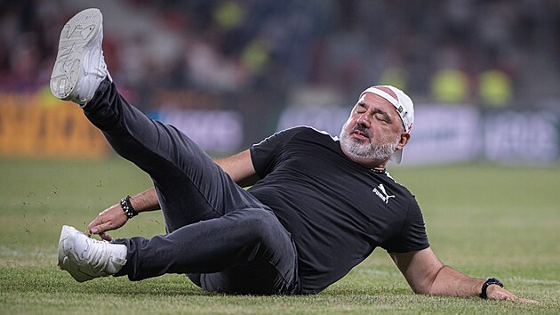 Sl�vistick� tren�r Jind�ich Trpi�ovsk� slav� v�hru nad Ban�kem skluzem po tr�v�.