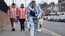 Fanou�ek Manchesteru City, za ním t�i p�íznivci Sheffieldu United p�icházejí ke...