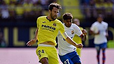 Lamine Yamal (v bílém) z Barcelony napadá v zápase s Villarrealem, k míi má...