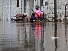 Eliah Corcoran sedí na lavice v záplavové vod po pechodu hurikánu Idalia v...