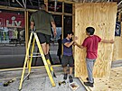 Pracovníci baru a grilu Toucans zabedují okna restaurace ped hurikánem Idalia...