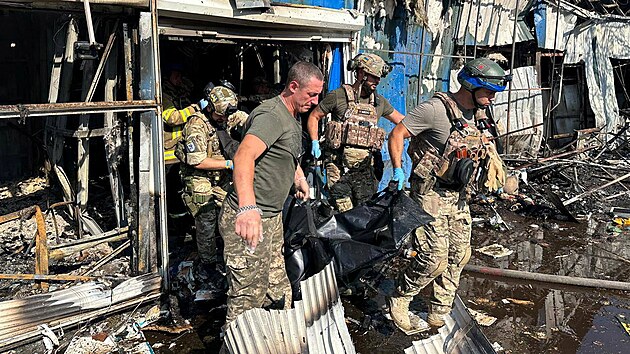 Policisté a záchranáři nesou tělo člověka zabitého při ruském útoku na Kosťantynivku. (6. září 2023)