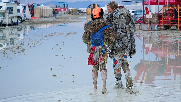 Dvojice prochzejc bahnem na festivalu Burning Man. (2. z 2023)