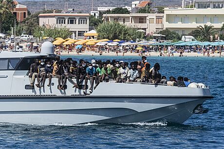 Migranti piplouvají na lodi Guardia di Finanza v pístavu italského ostrova...