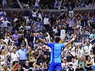 Srbský tenista Novak Djokovi se raduje spolen s diváky bhem finále US Open.
