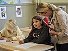Uitelka pomáhá ákyni procviovat rukopis na základní kole Djurgardsskolan ve...
