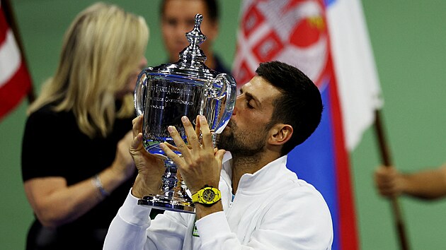 Srbský tenista Novak Djokovič líbá trofej pro vítěze US Open.