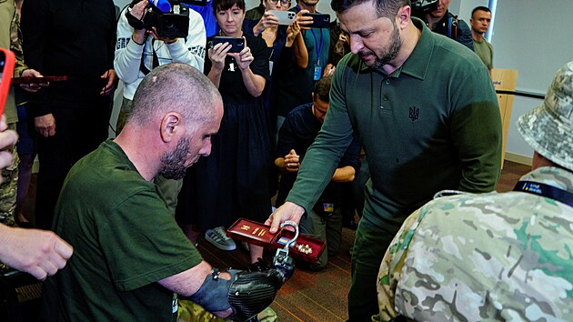 Ukrajinský prezident Volodymyr Zelenskyj předává ocenění zraněnému vojákovi při návštěvě univerzitní nemocnice Staten Island v New Yorku, kde se ukrajinští vojáci léčí z válečných zranění. (18. září 2023)