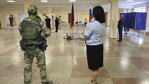 Voják střeží volební místnost během místních voleb v Doněcku v Ruskem okupované Doněcké oblasti. (10. září 2023)