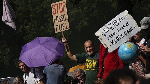 V nizozemském Haagu protestovali klimatičtí aktivisté. Jeden z nich drží ceduli s nápisem „Stop fosilním palivům“. (9. září 2023)