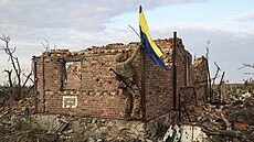 Ukrajinský voják vztyčuje vlajku v troskách osvobozené vesnice Andrijivka...
