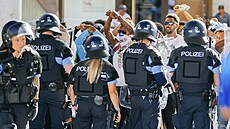 Skupina lidí je obklíena policejními silami po nepokojích na akci v nmeckém...