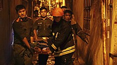 Záchranái vynáejí z hoící budovy v Hanoji ve Vietnamu lovka na nosítkách....