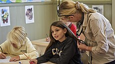 Učitelka pomáhá žákyni procvičovat rukopis na základní škole Djurgardsskolan ve...