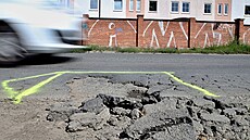 Poničený povrch Lobezské ulice v Plzni. Silničáři označili úsek výstražnou...