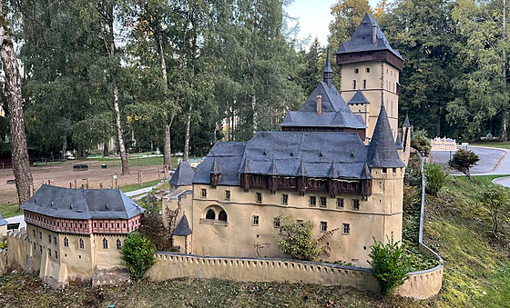 Pokozený model hradu Karltejn a poárem zniený stánek oberstvení v parku...
