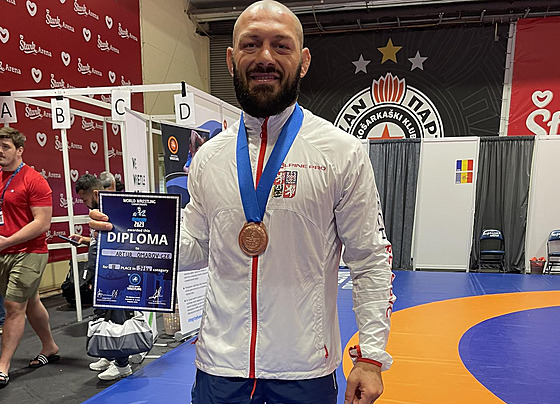 Artur Omarov pózuje s bronzovou medailí a diplomem.