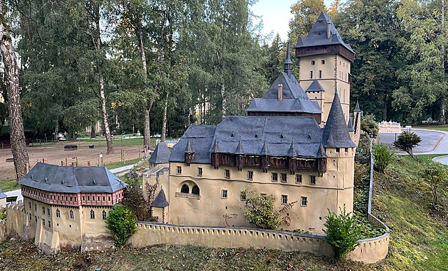 Poškozený model hradu Karlštejn a požárem zničený stánek občerstvení v parku...