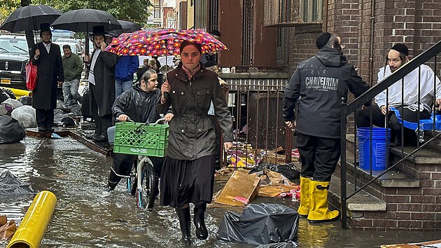 Chodci jsou na zaplaveném chodníku v newyorské čtvrti Brooklyn. (29. září 2023)