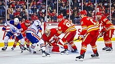 Branká Calgary Flames Dan Vlada hledá kotou ve skrumái ped brankou bhem...