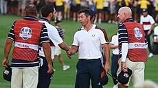 Rory McIlroy z Týmu Evropy (vpravo) si podává ruku s Patrickem Cantlayem z USA.