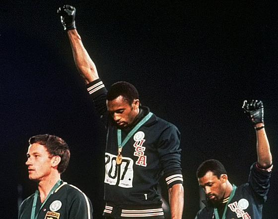 Amerití sprintei Tommie Smith (uprosted) a John Carlos (vpravo) na olympiád...