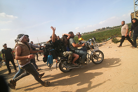 Palestinci peváejí zajatou izraelskou civilistku z kibucu Kfar Azza do pásma...