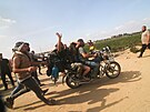 Palestinci peváejí zajatou izraelskou civilistku z kibucu Kfar Azza do pásma...