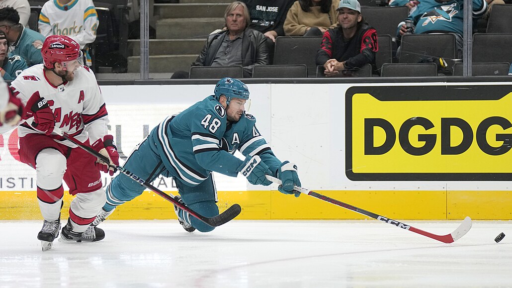 Tomá Hertl (48) ze San Jose Sharks se natahuje po puku v zápase s Carolina...