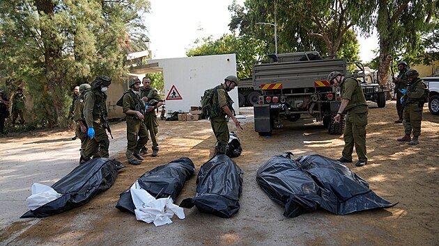 Izraelt vojci stoj vedle tl Izraelc zabitch militanty Hamsu v kibucu Kfar Aza. (10. jna 2023)