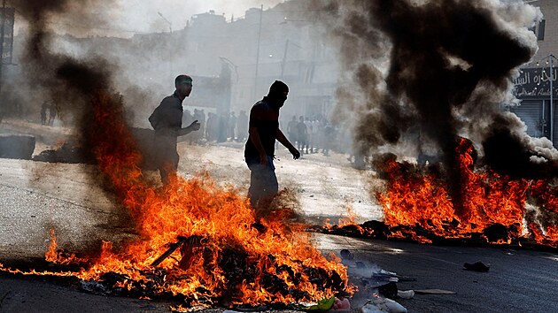 Palestinci krej kolem ohn bhem protestu ve mst Nblus po izraelskch tocch. (13. jna 2023)