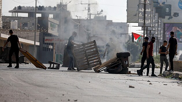 Palestinci krej kolem ohn bhem protestu ve mst Nblus po izraelskch tocch. (13. jna 2023)