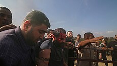 Palestinci peváejí zajatého izraelského civilistu z kibucu Kfar Azza do pásma...