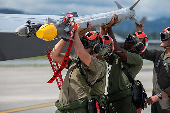 Amerití vojáci nakládají stely AIM-9X Sidewinder na letoun Hornet na letecké...
