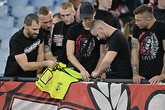 Slávistití ultras i s vestou poadatele, na které jsou po potykách na tribun...