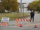 Policista stojí u uzavírky silnice poblí bowlingové dráhy v Lewistonu ve stát...