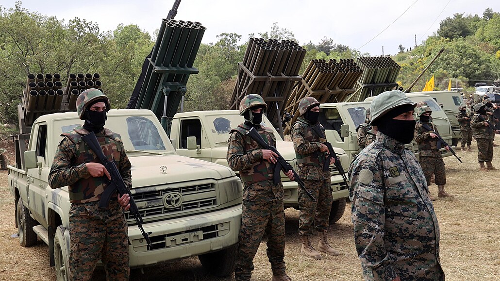 Bojovníci Hizballáhu stojí u nkolika raketomet v jiholibanonské vesnici...