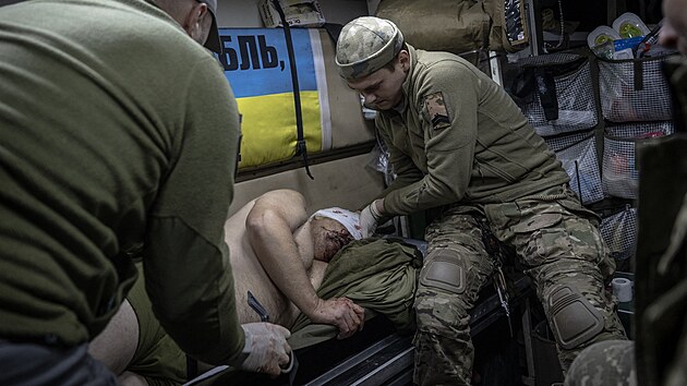 Zdravotníci ošetřují zraněného ukrajinského vojáka na frontě u města Avidijivka na Ukrajině (24. října 2023)