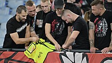 Slávistití ultras i s vestou poadatele, na které jsou po potykách na tribun...