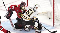 Matthew Poitras z Boston Bruins pekonává Petra Mrázka z Chicago Blackhawks.