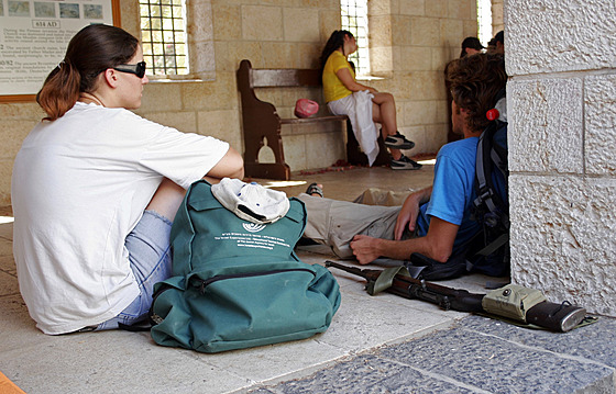 Mladí izraeltí studenti odpoívají ped kesanským kostelem, mnozí mají pi...