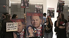 Lidé na demonstraci v Tel Avivu dr�í transparenty vyzývající n�meckého kanclé�e...