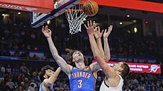 Nikola Joki� (vpravo) z Denveru bojuje o mí� s Joshem Giddeyem z Oklahoma City....