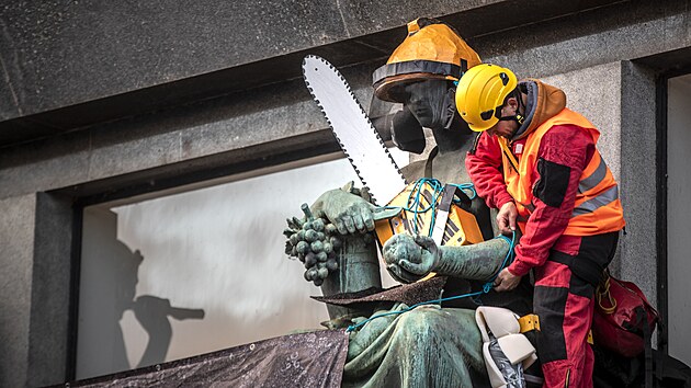 Aktivist Greenpeace sochm nad vchodem ministerstva nasadili paprov helmy a dali jim do rukou makety motorovch pil. (8. listopadu 2023)