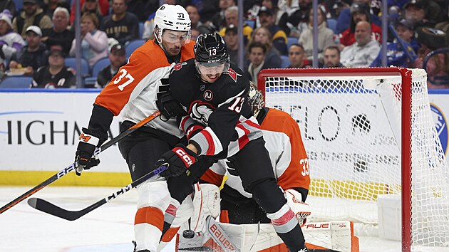 Luk� Rousek z Buffala v souboji p�ed brankou s Louiem Belpediem.