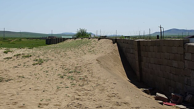 Vítr zanáší písek na nedalekou osadu. Zdejší ochrannou stěnu už téměř překonal.